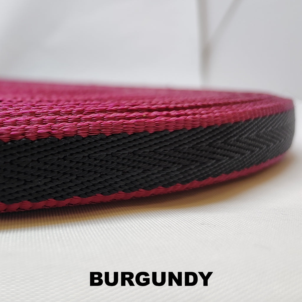 Roll of burgundy herringbone webbing with single thick black stripe running down the centre