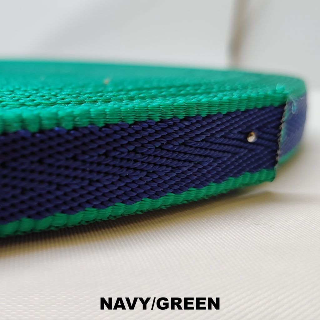 Roll of light green herringbone webbing with a single navy blue thick stripe running down the centre
