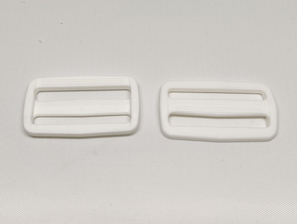 Two white plastic 50 millimetre triglide buckles